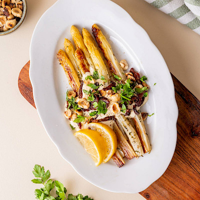 Asperges uit de oven met bacon, verse peterselie en hazelnoten